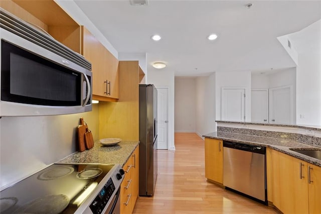 390 17th St NW Unit 6036, Atlanta, GA 30363 - kitchen featuring appliances with stainless steel finishes, light wood finished floors, dark stone counters, and recessed lighting