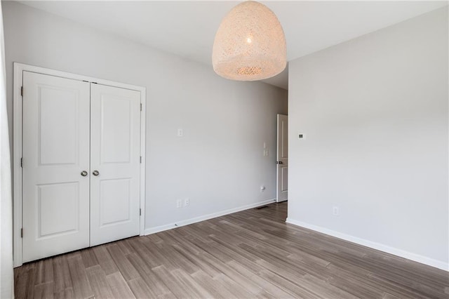 unfurnished bedroom with a closet and hardwood / wood-style floors