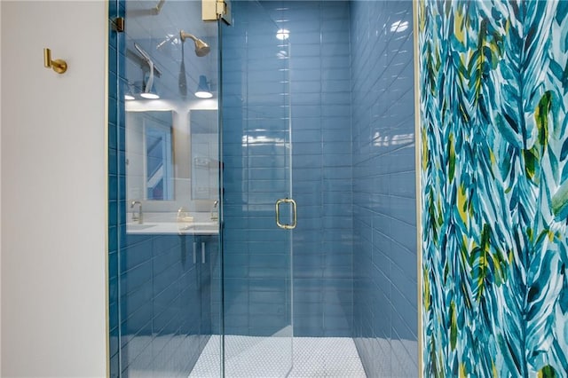 bathroom with a shower with shower door and sink