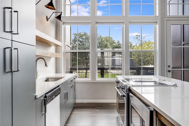 kitchen with sink, stainless steel appliances, and light hardwood / wood-style floors