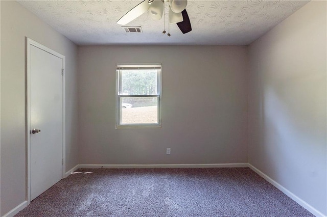 carpeted empty room with a ceiling fan, baseboards, visible vents, and a textured ceiling
