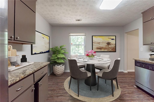 dining area featuring baseboards, visible vents, a textured ceiling, and dark wood-type flooring