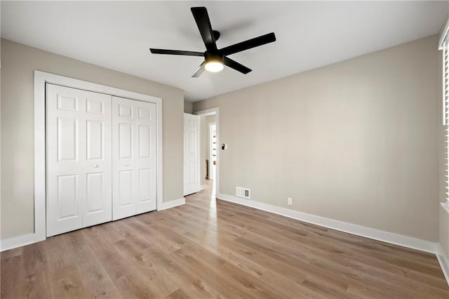 unfurnished bedroom featuring light hardwood / wood-style flooring, a closet, and ceiling fan