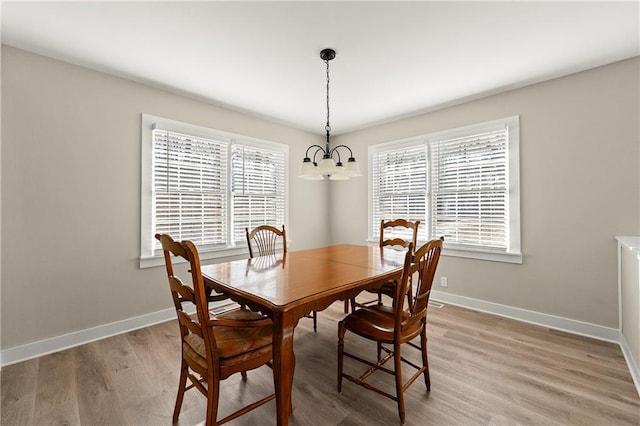 dining area featuring a notable chandelier and light hardwood / wood-style floors