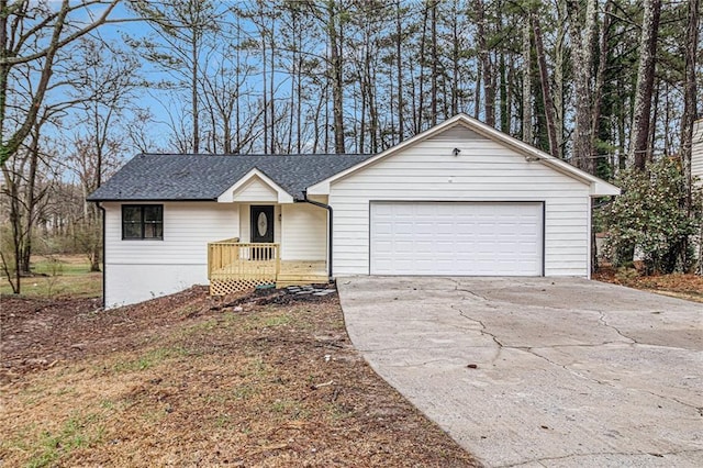 ranch-style house featuring a garage, a shingled roof, and concrete driveway