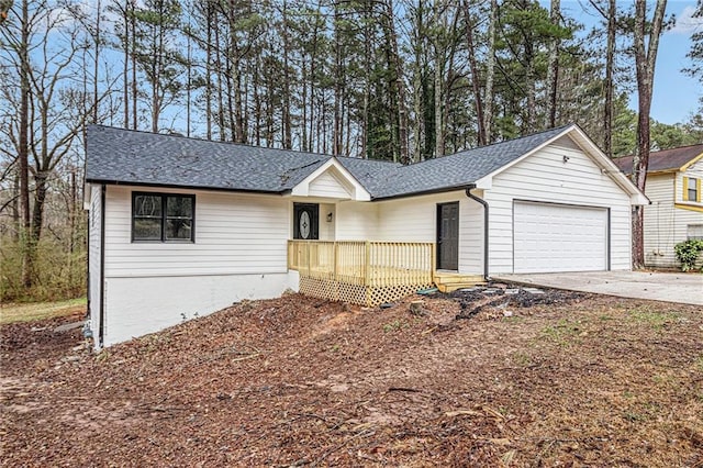 ranch-style home featuring a shingled roof, concrete driveway, and an attached garage