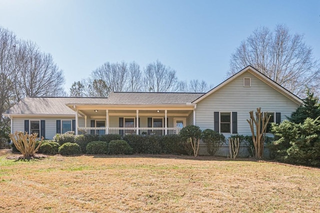 view of front of home featuring covered porch, a shingled roof, and a front yard