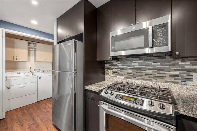 kitchen with stainless steel appliances, dark hardwood / wood-style flooring, washing machine and dryer, and decorative backsplash