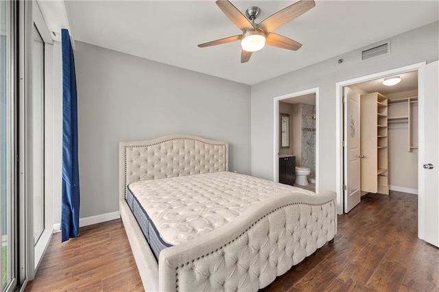 bedroom with ceiling fan, a closet, dark wood-type flooring, and a spacious closet