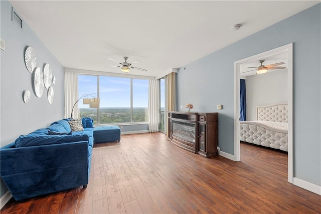 living room featuring ceiling fan and dark hardwood / wood-style flooring