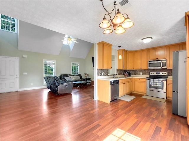 1012 Gloria Grand Blvd, Mcdonough, GA 30252 - kitchen with stainless steel appliances, open floor plan, light countertops, a ceiling fan, and decorative backsplash