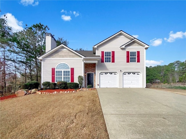 tri-level home with a garage, a front lawn, a chimney, and driveway