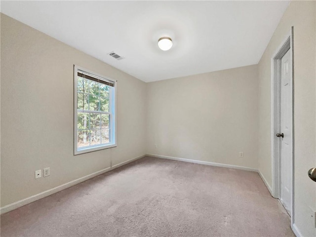 carpeted empty room featuring visible vents and baseboards