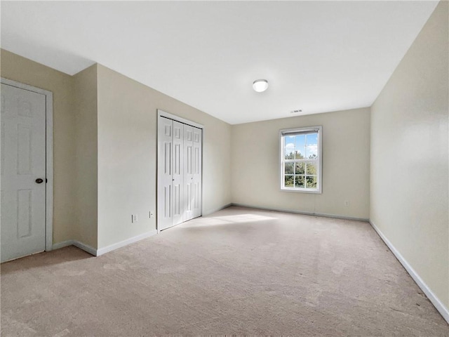 unfurnished bedroom with a closet, baseboards, visible vents, and carpet flooring