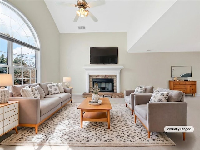 living area featuring visible vents, a fireplace, lofted ceiling, and a ceiling fan