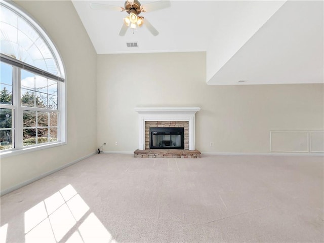 unfurnished living room with visible vents, carpet floors, a fireplace, baseboards, and ceiling fan