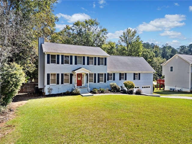 colonial-style house featuring a front lawn and a garage