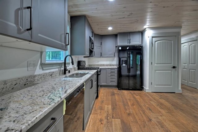 kitchen with sink, gray cabinetry, hardwood / wood-style floors, black appliances, and wooden ceiling