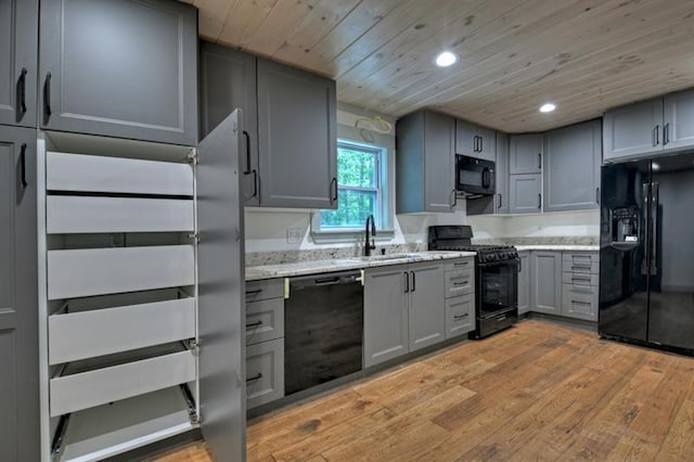 kitchen with gray cabinets, sink, light hardwood / wood-style floors, black appliances, and wooden ceiling