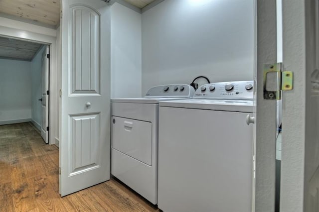 laundry area featuring separate washer and dryer and light hardwood / wood-style flooring