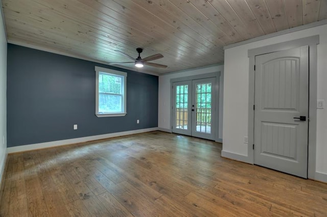 empty room with plenty of natural light, wood ceiling, light hardwood / wood-style floors, and french doors