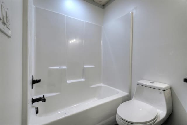 bathroom featuring shower / bathtub combination and toilet