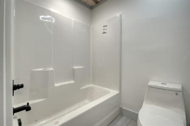 bathroom with tile patterned flooring, shower / bathing tub combination, and toilet