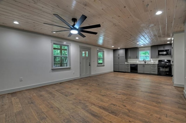 unfurnished living room featuring sink, wood-type flooring, wooden ceiling, and ceiling fan