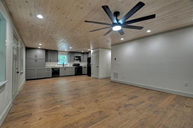 unfurnished living room with ceiling fan, sink, wooden ceiling, and light hardwood / wood-style floors