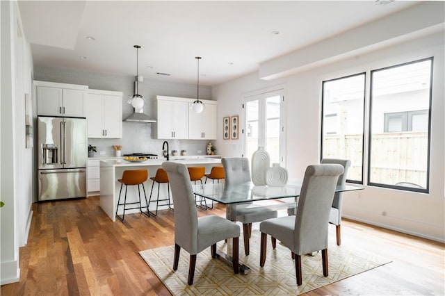 dining space with sink and light hardwood / wood-style floors