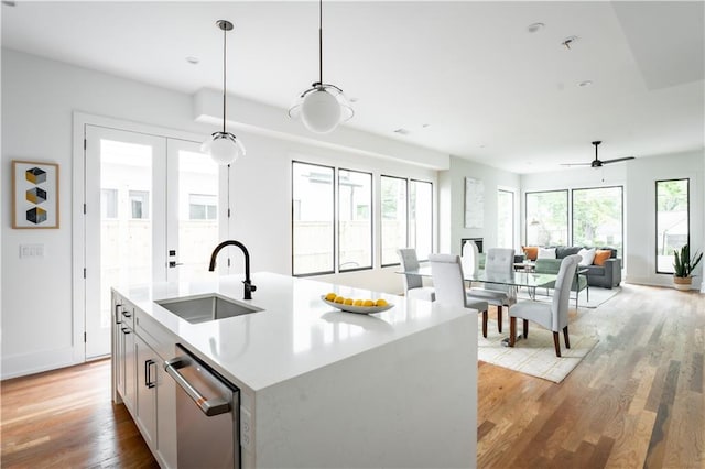 kitchen with hanging light fixtures, a healthy amount of sunlight, stainless steel dishwasher, and sink