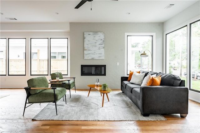 living room with light hardwood / wood-style flooring and ceiling fan