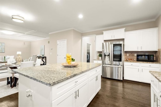 kitchen with black microwave, a kitchen island, white cabinets, refrigerator with glass door, and dark wood finished floors