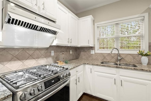 kitchen featuring stainless steel gas range oven, under cabinet range hood, a sink, white cabinets, and light stone countertops