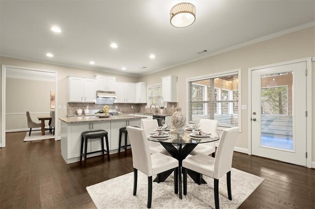 dining area featuring ornamental molding, dark wood-type flooring, visible vents, and baseboards