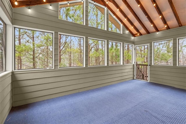 unfurnished sunroom featuring lofted ceiling with beams