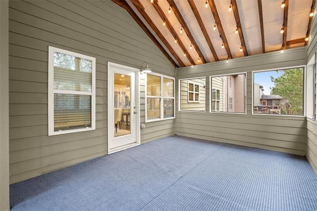 unfurnished sunroom with vaulted ceiling with beams