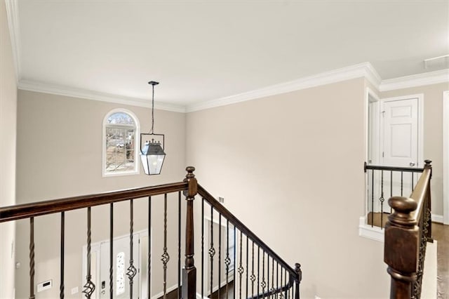 corridor with baseboards, visible vents, crown molding, and an upstairs landing