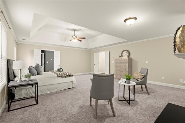 bedroom featuring a tray ceiling, carpet, and baseboards