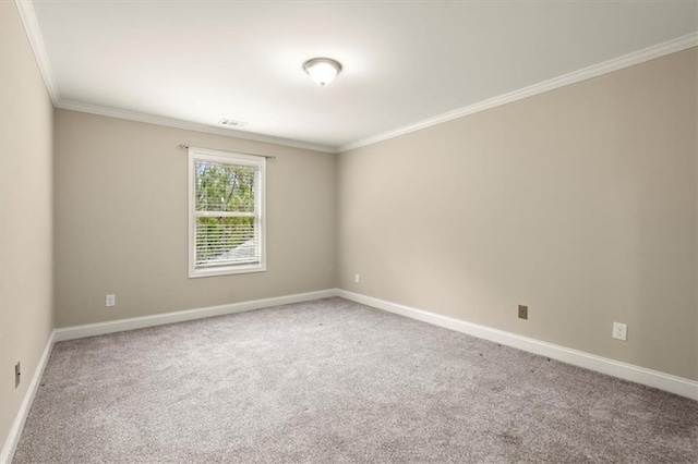 carpeted empty room with ornamental molding, visible vents, and baseboards