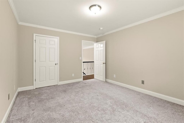 unfurnished bedroom featuring baseboards, crown molding, and light colored carpet