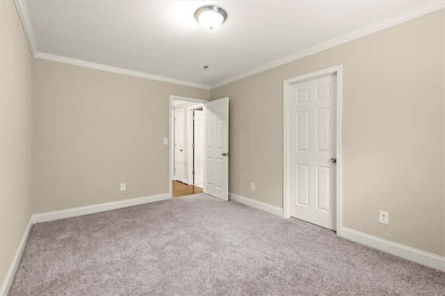 unfurnished bedroom with carpet floors, ornamental molding, and baseboards