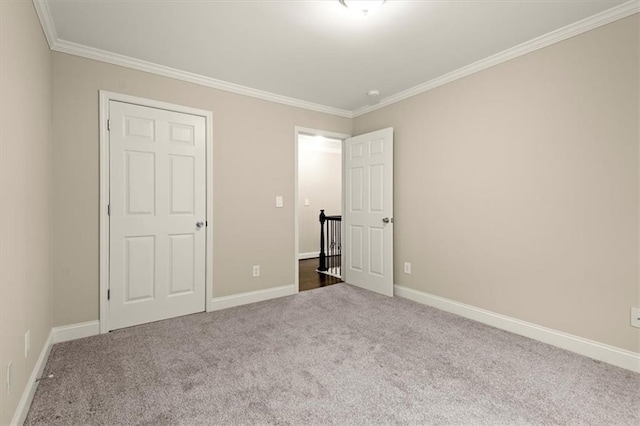 unfurnished bedroom with carpet floors, baseboards, and ornamental molding