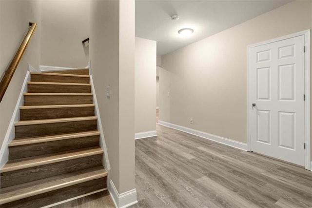 stairway featuring baseboards and wood finished floors