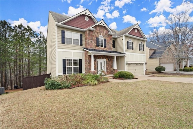 craftsman inspired home with stone siding, concrete driveway, fence, and a front yard