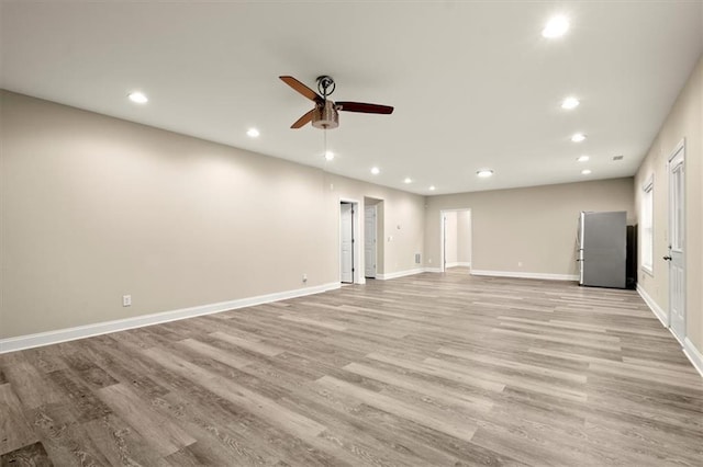 unfurnished living room with light wood-style flooring, baseboards, ceiling fan, and recessed lighting