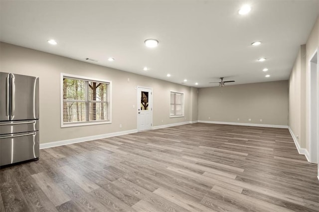 unfurnished living room featuring recessed lighting, visible vents, light wood-style flooring, ceiling fan, and baseboards