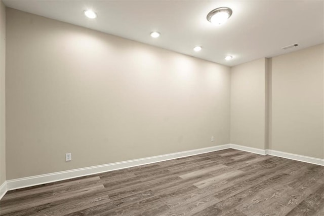 empty room with visible vents, baseboards, dark wood-style flooring, and recessed lighting