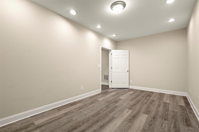 spare room featuring baseboards, visible vents, dark wood finished floors, and recessed lighting