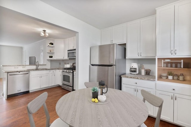 kitchen featuring appliances with stainless steel finishes, sink, white cabinets, and dark hardwood / wood-style floors